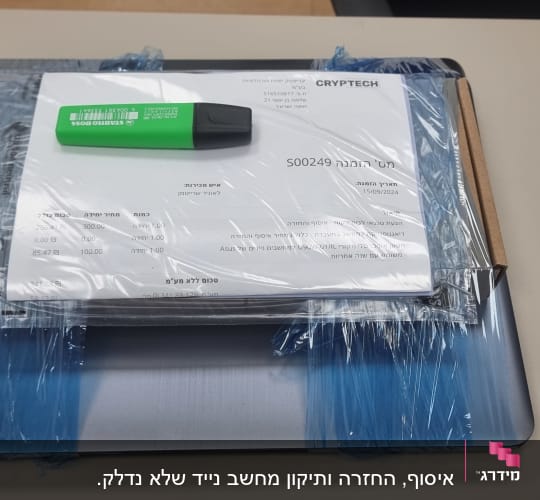 מסמכים ועט על מחשב נייד עטוף בניילון
